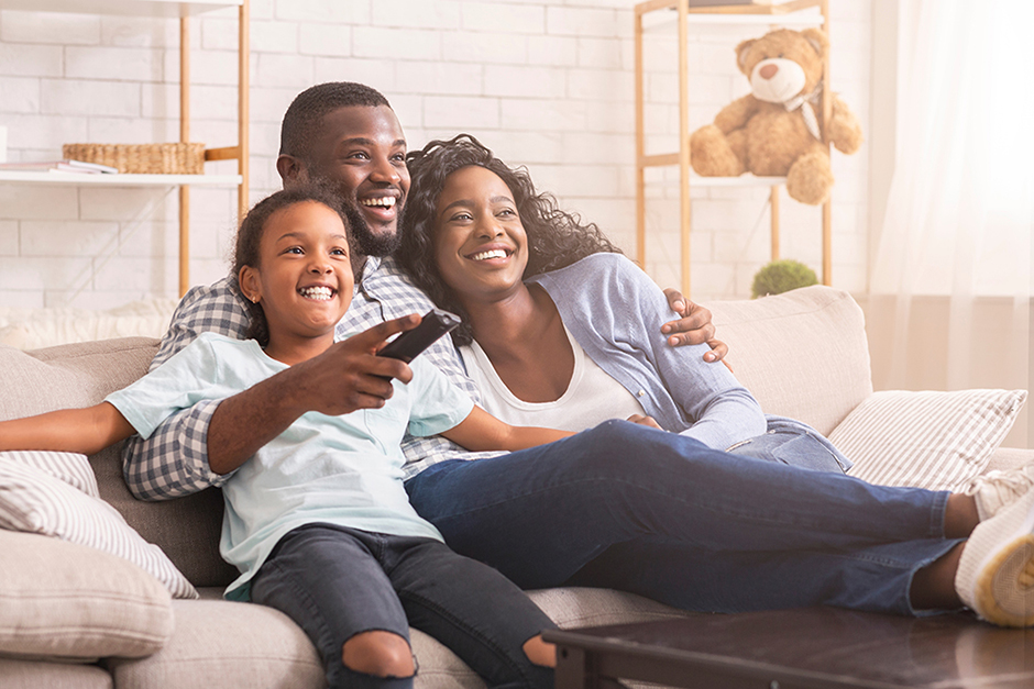 Family on a couch watching TV together