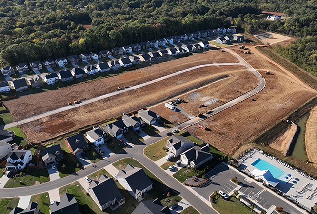 An aerial view of the Murfreesboro community, showing the homes and the streets of the neighborhood. The amenities offered are shown, including a large outdoor pool
