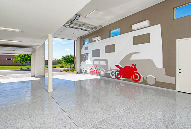 Ultra Garage which has enough room to store an RV or a boat, there is high ceilings, two separate garage doors, and a large image of an RV on the right wall