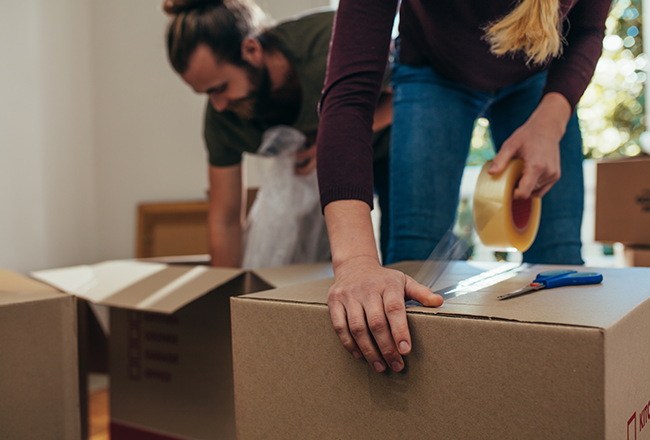 Couple taping up moving boxes