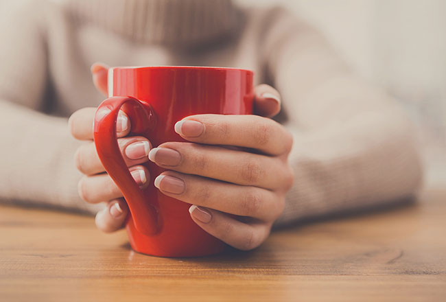 Hands gripping a red mug