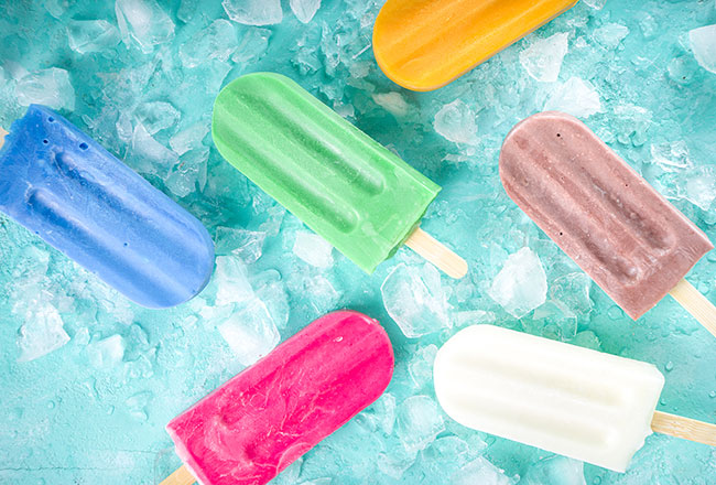 Frozen ice pops of different flavors against a blue background
