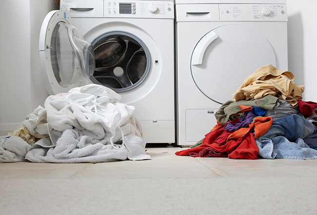 Washer and dryer with two color-separated piles of laundry in the foreground