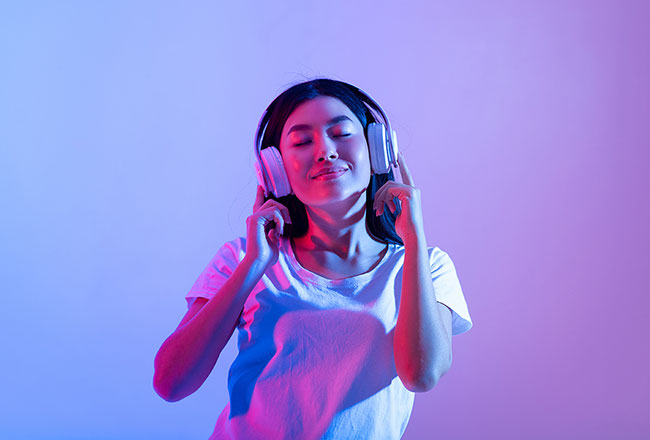 Woman with headphones, listening with her eyes closed