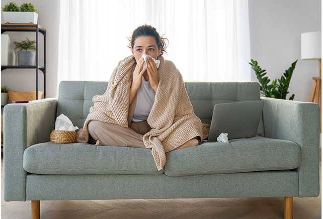 A woman rubbing her nose with a tissue