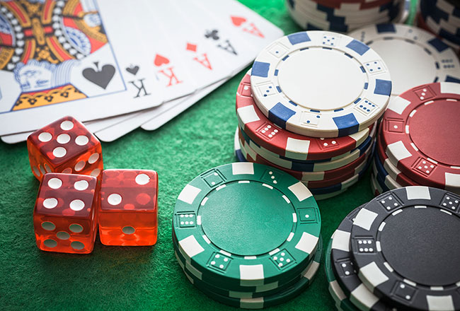 Playing cards, dice and poker chips on green felt