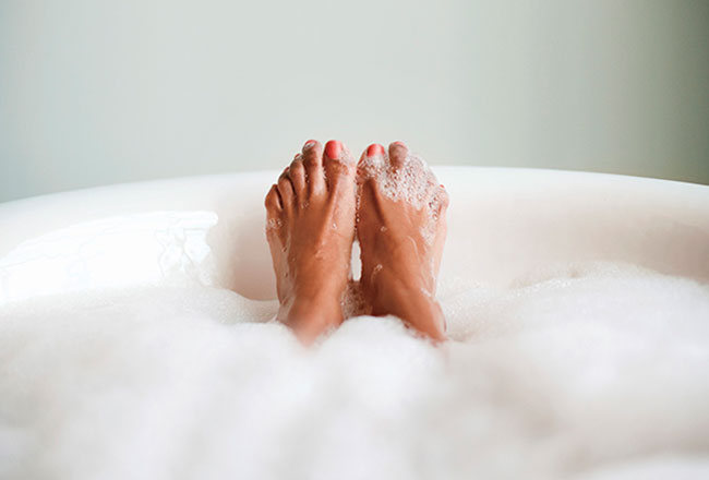 Feet sticking out of a hot bubble bath