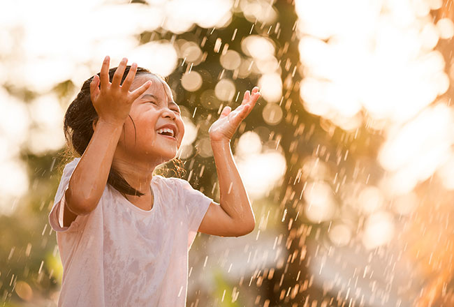 Girl playing in a lawn sprinkler