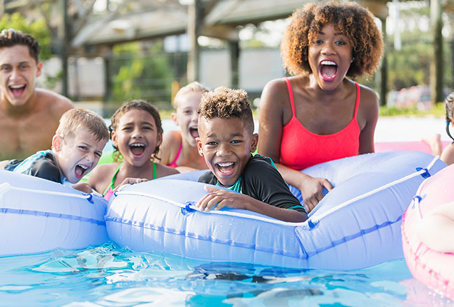 Children and adults playing in a swimming pool