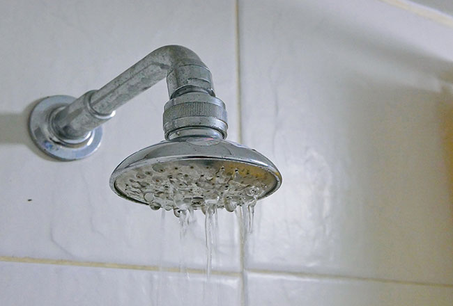 A showerhead dribbling water weakly