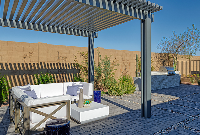 Back patio with outdoor kitchen and pergola covering lounge area.