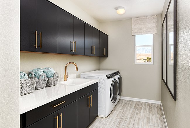 Laundry room with upper and lower cabinets, sink, washer, dryer, and window.