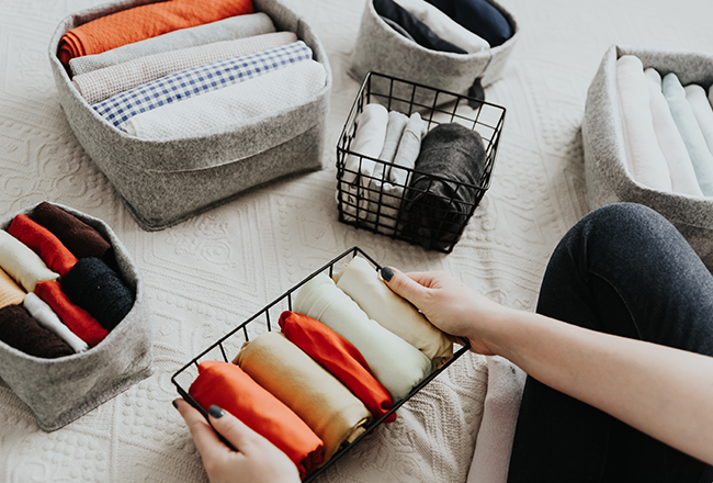 Person organizing clothing in different containers