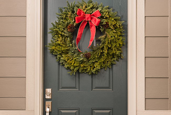 Front door adorned with a holiday wreath