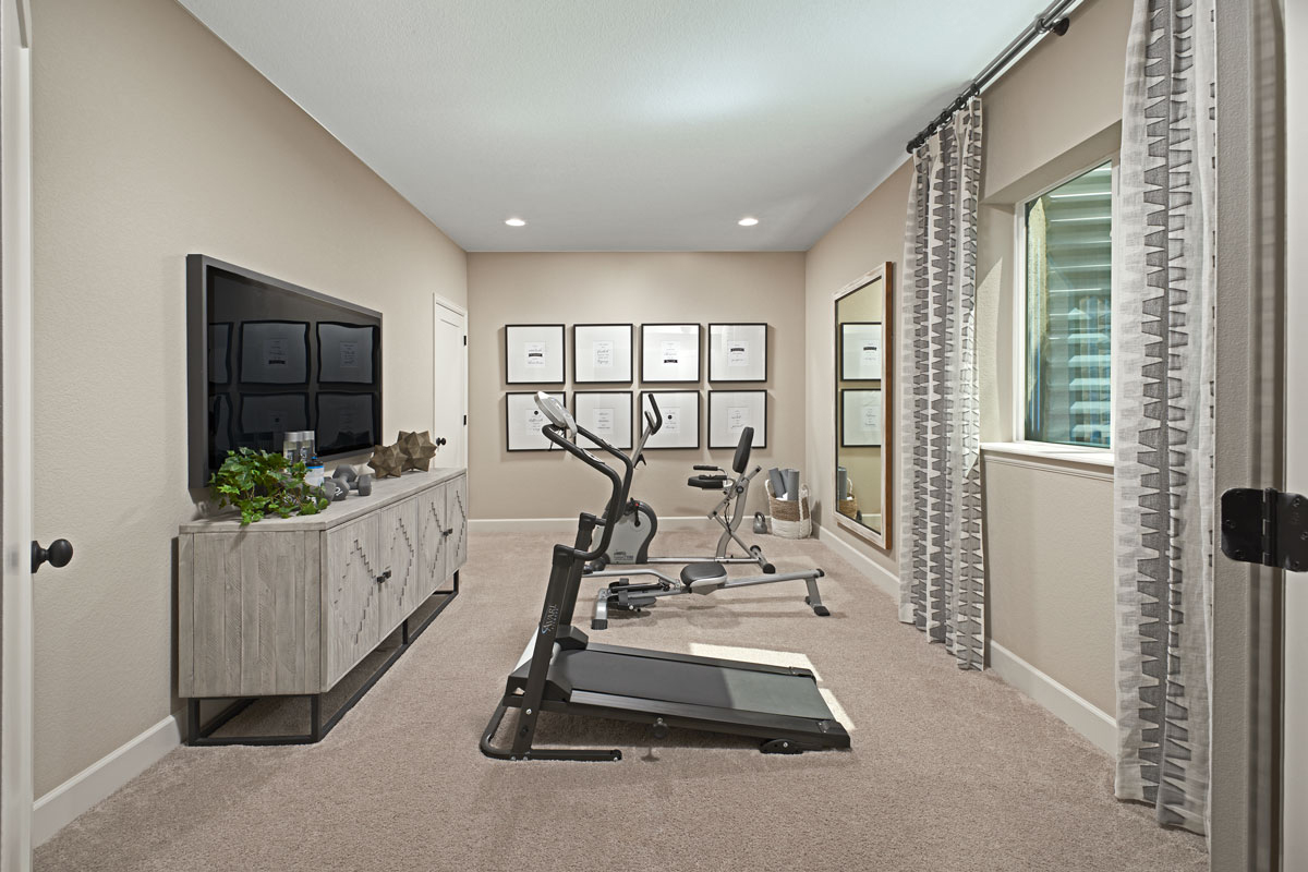 Basement h9ome gym with machines and a TV