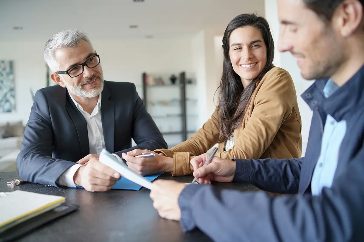 Buyers with Agent looking at paper work