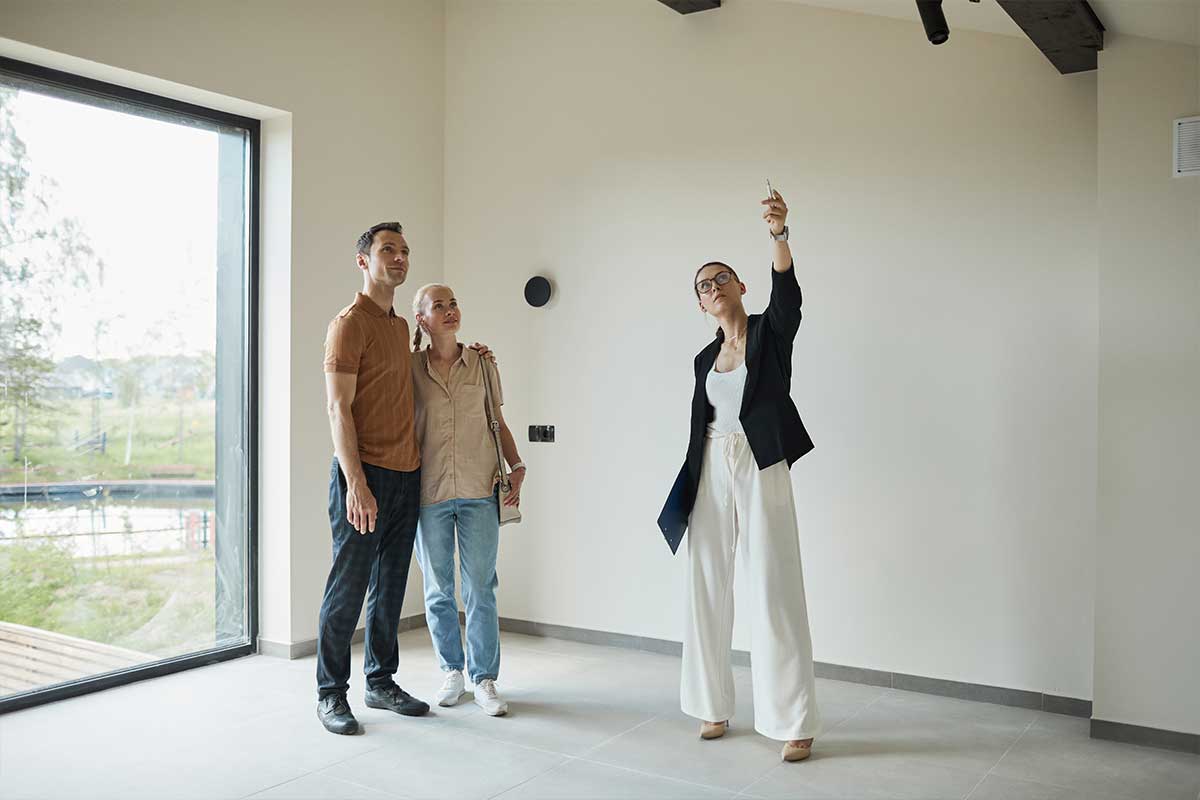 real estate agent showing a home to a young couple