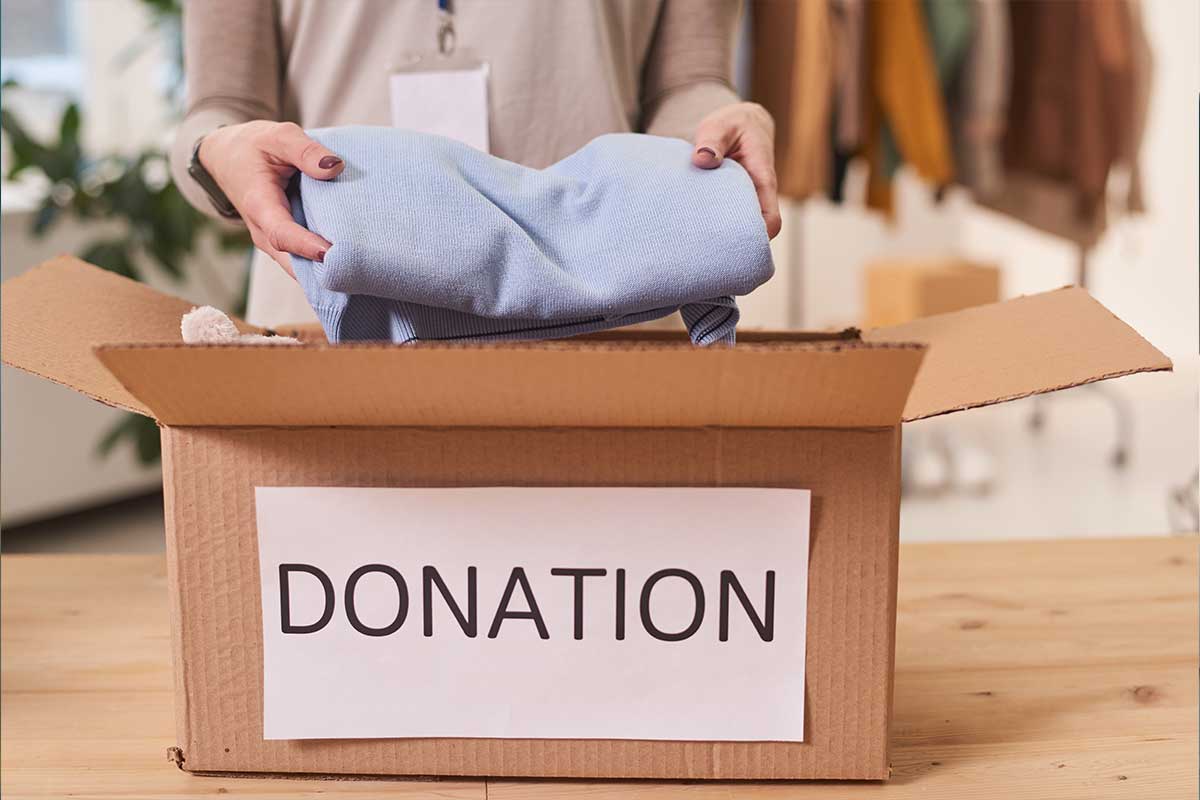 Woman preparing clothes for a charitable donation