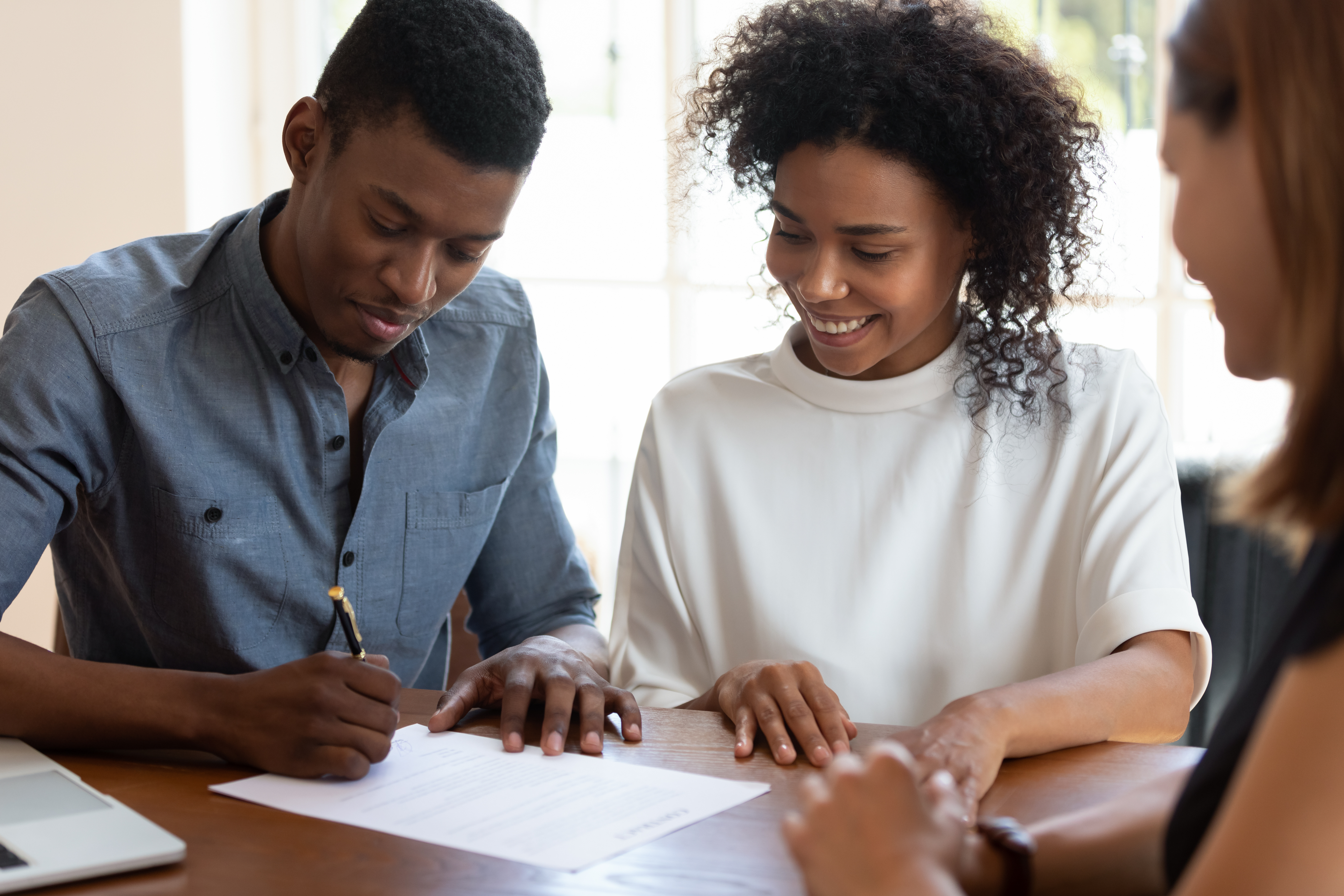 Happy couple signing their mortgage papers