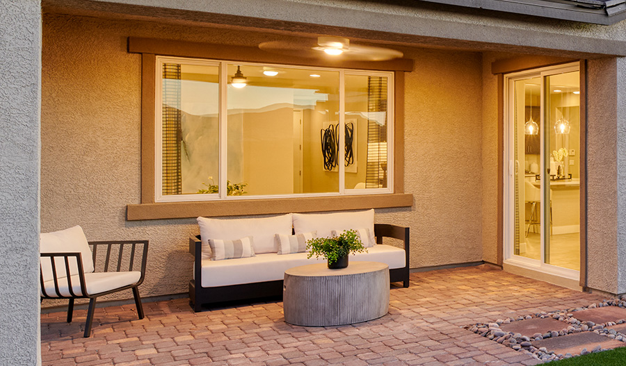 A covered patio lit by a ceiling fan light