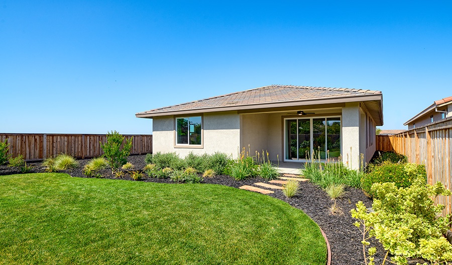 An inviting backyard with a mix of grass, mulch, and landscaping