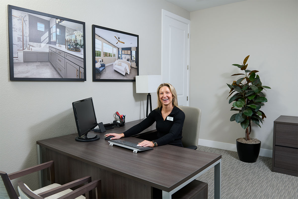 A sales associate smiling at her desk in the Sales Center