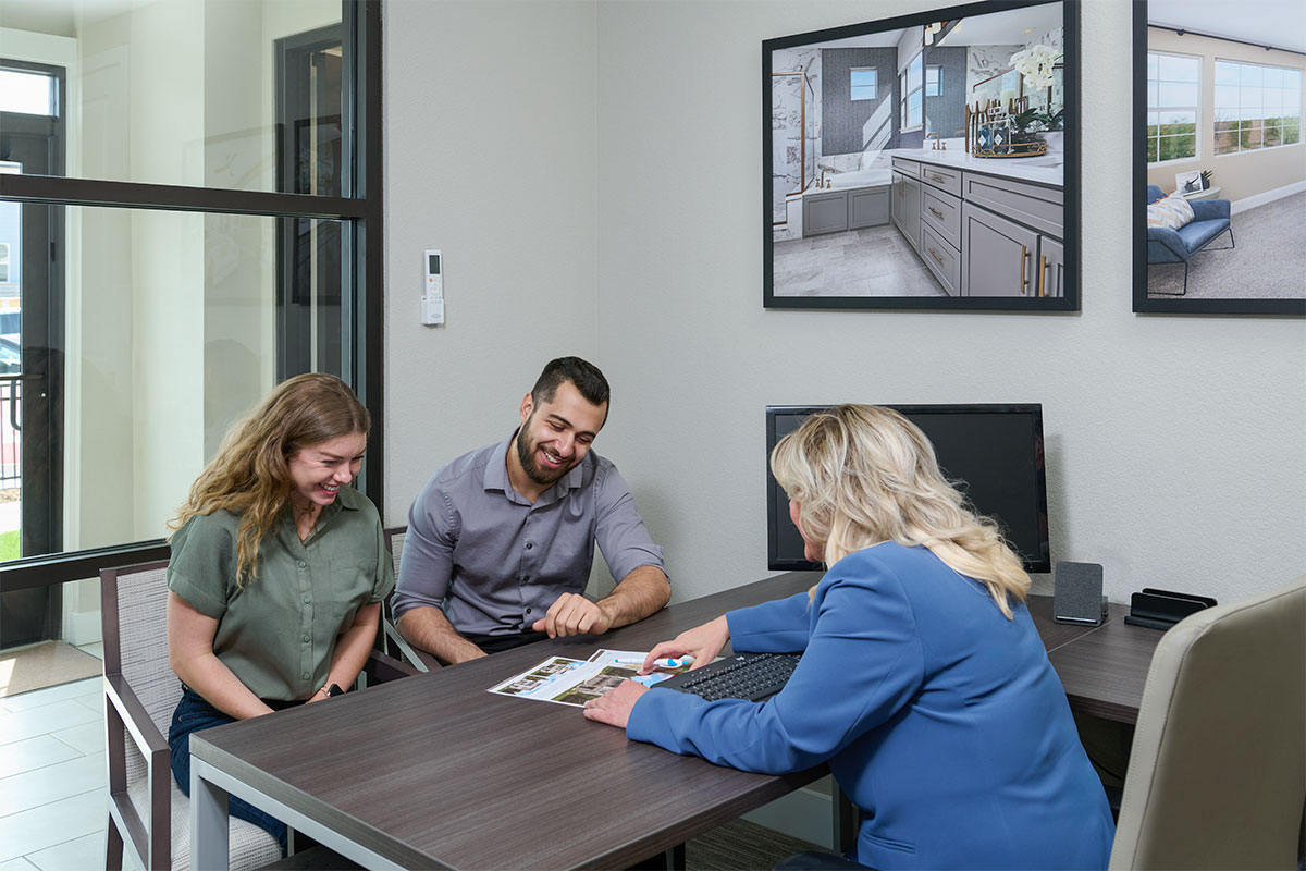 A young couple chatting with a sales associate in a Sales Center