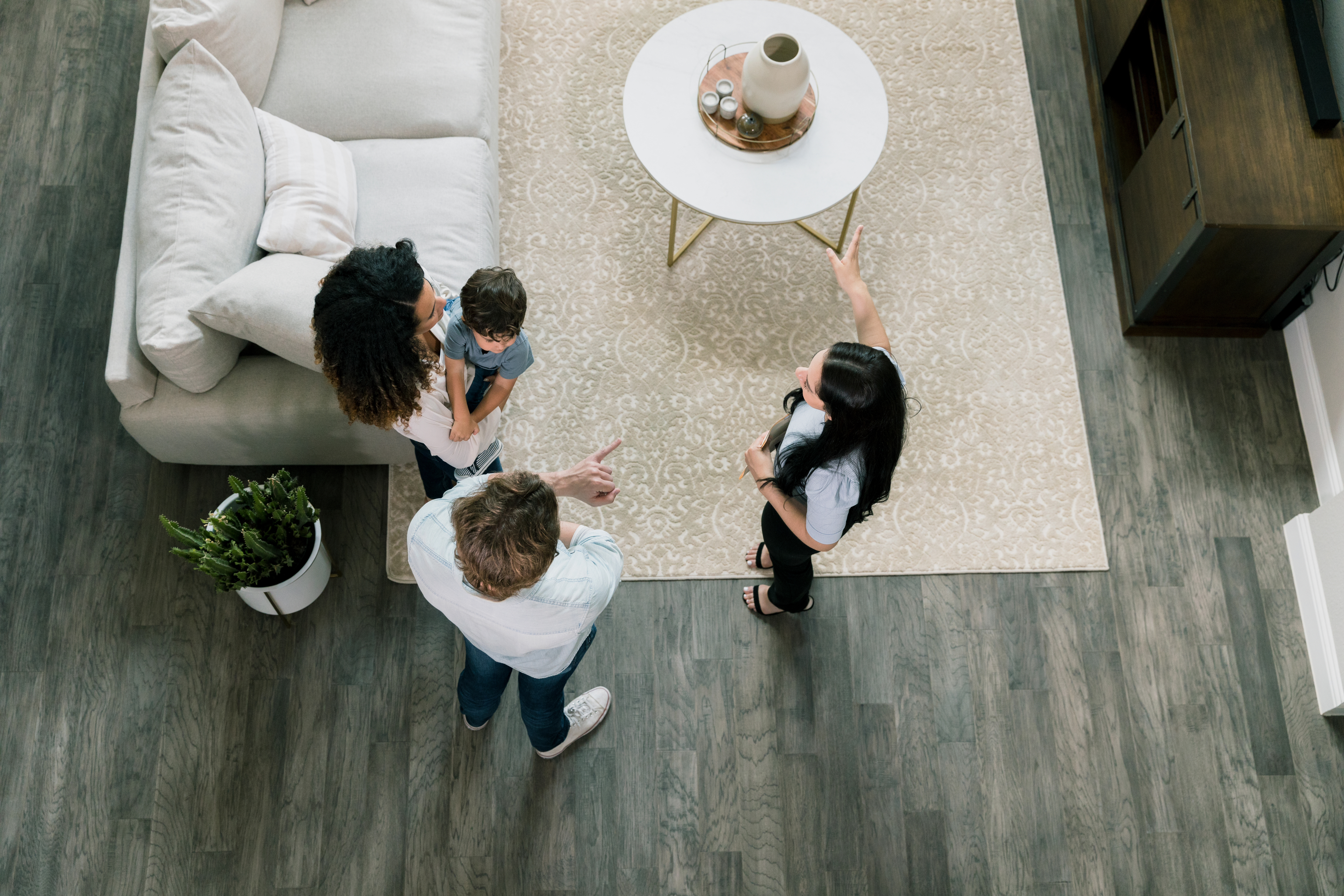 A community guide showing two homebuyers and their child around a house