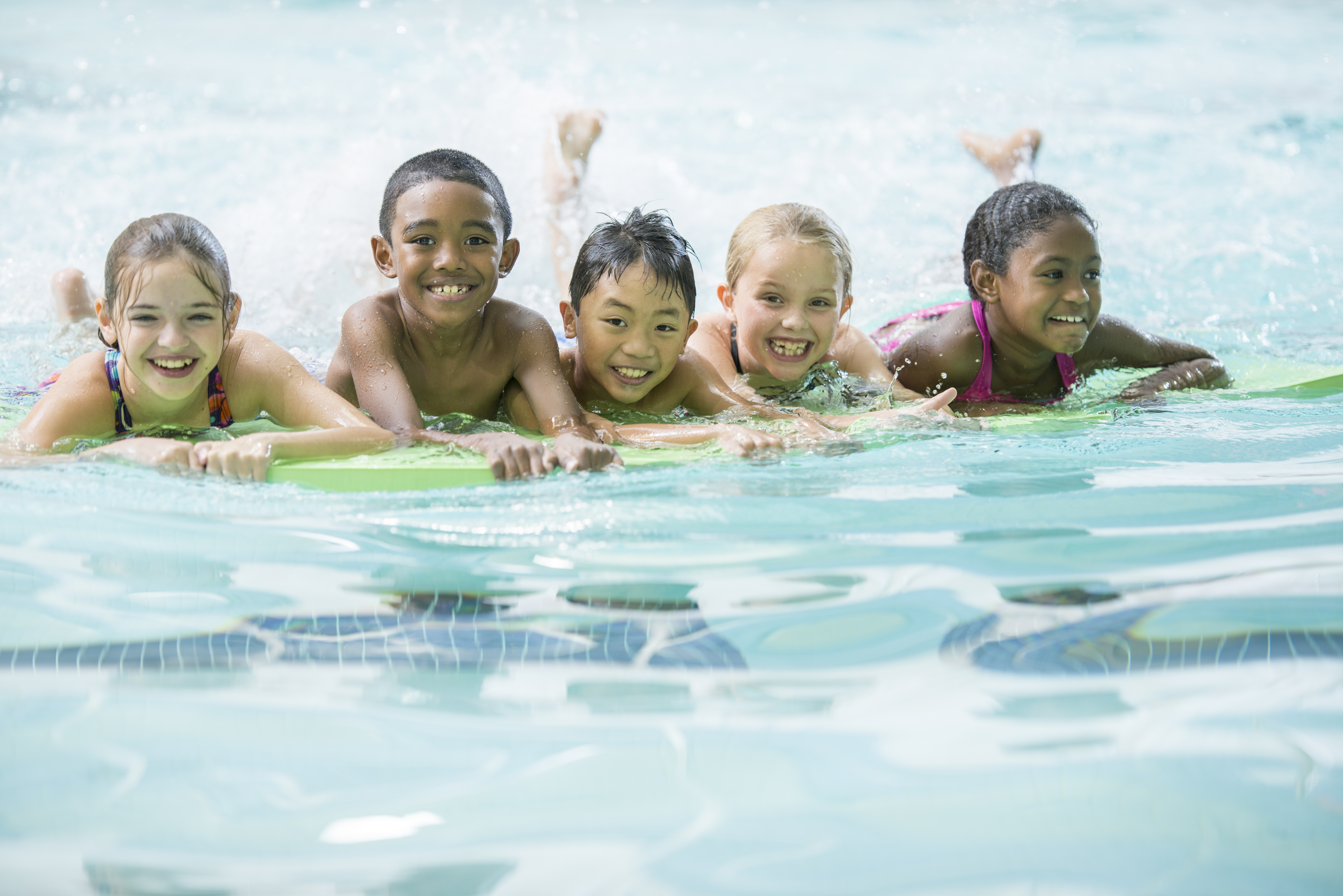 A group of kids swimming together in a pool