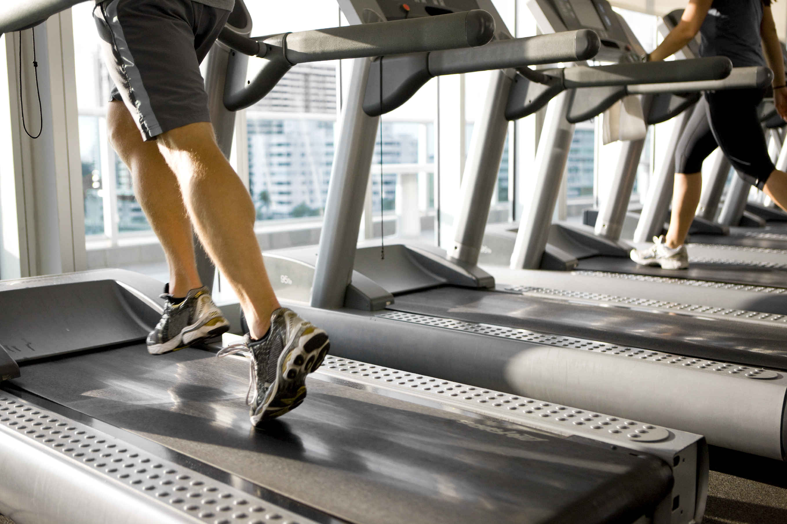 People running on treadmills at an indoor gym