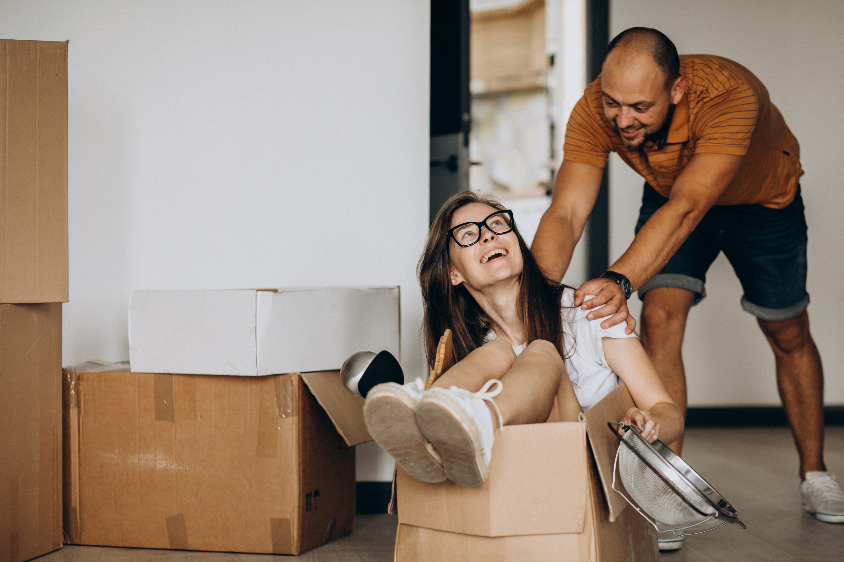 A man pushing a woman in a moving box