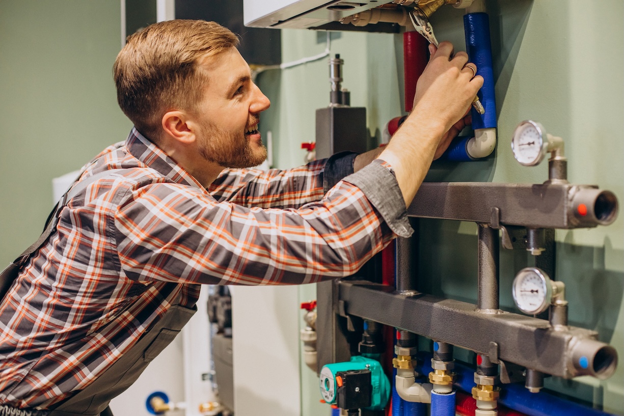 A man with tools working on a heating system