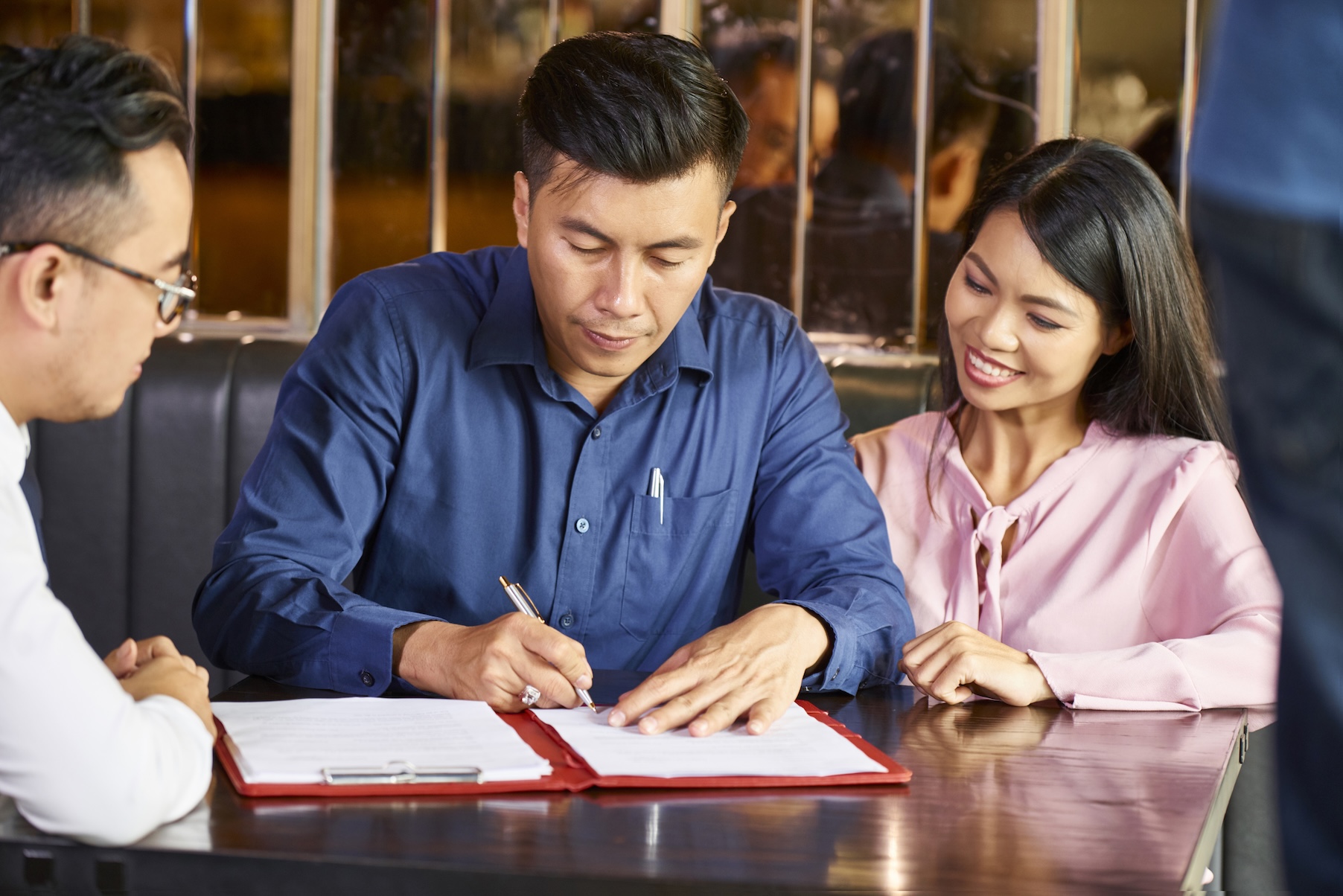 A couple signing homeowners insurance papers