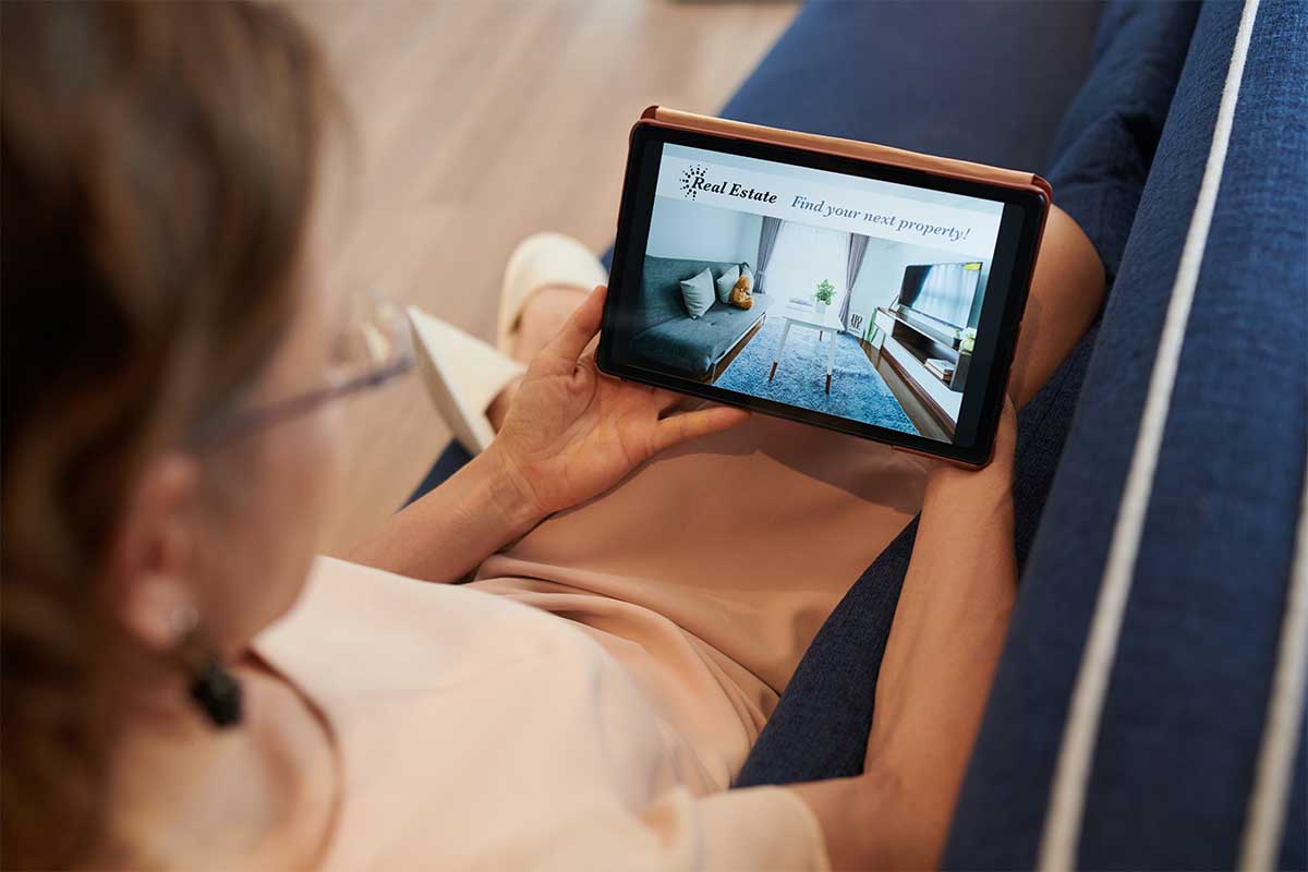 Woman watching a video from one of zillow and redfin on her tablet