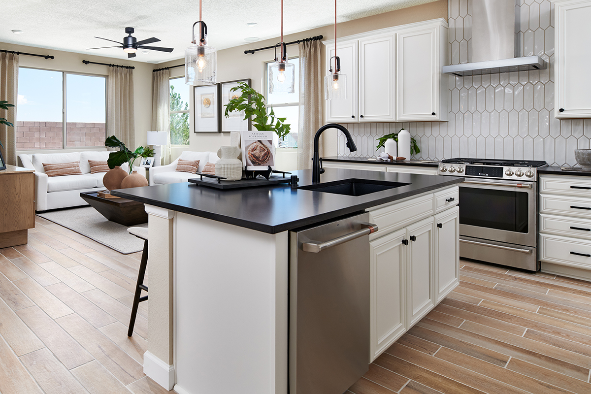 An elegant kitchen with an island overlooking a living room