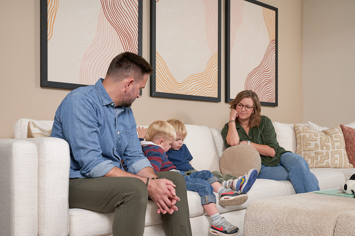 Two parents and their young children sitting on a couch