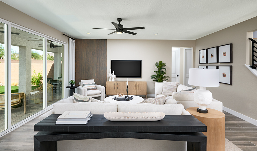 A well-decorated great room with wall art, a white couch, and decorative throw pillows