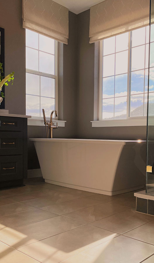 Sunlight streaming in through bathroom windows by a soaking tub