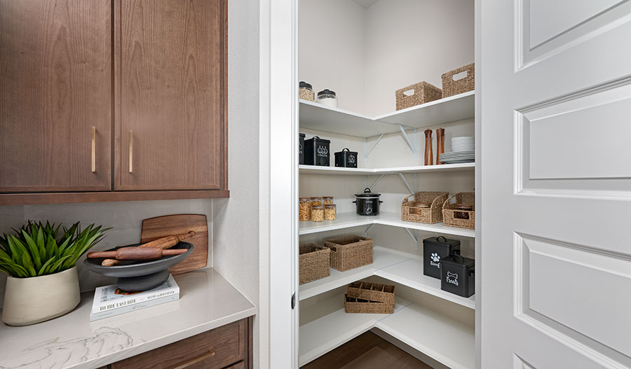 A walk-in pantry with wrap-around shelving