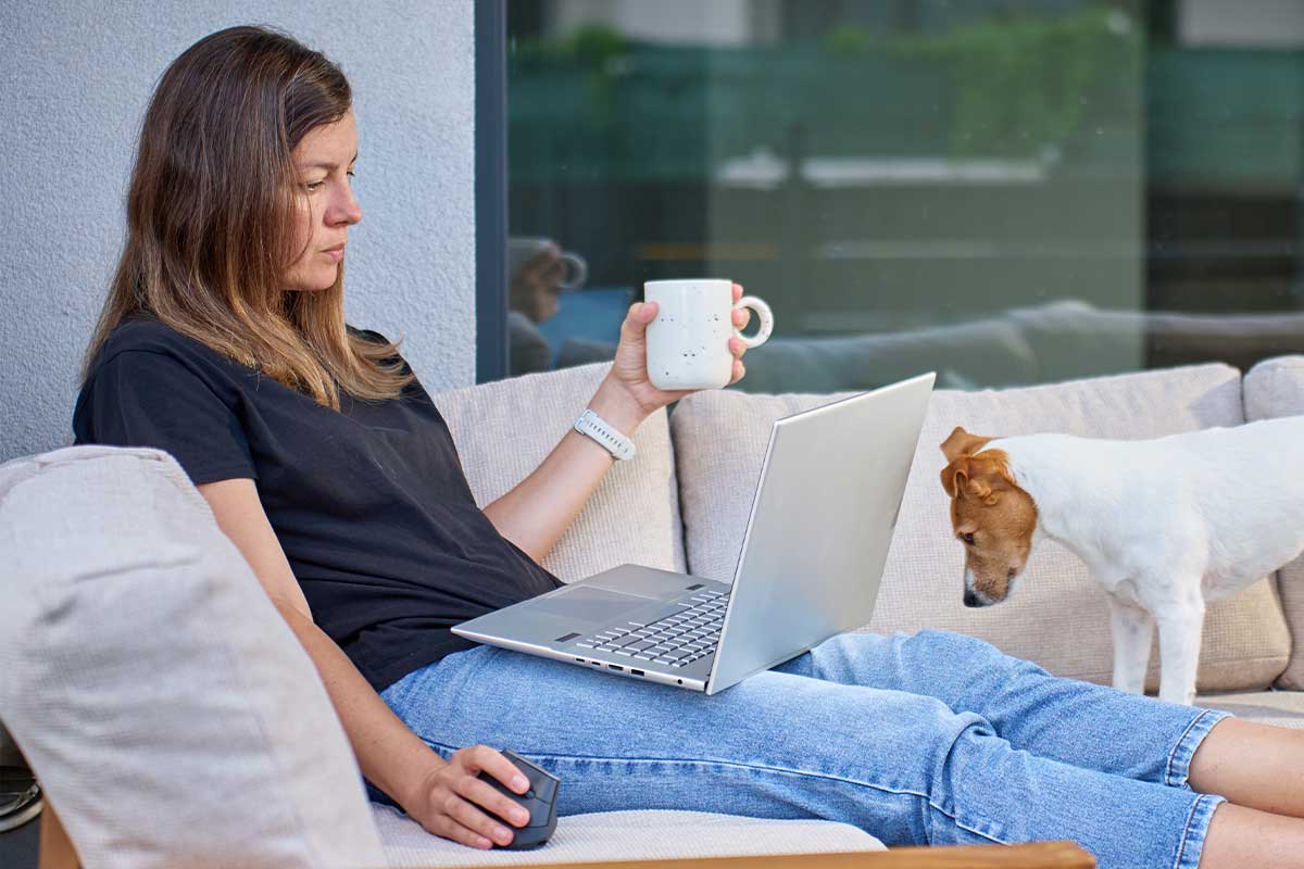 Woman drinking coffee on a sofa on her patio