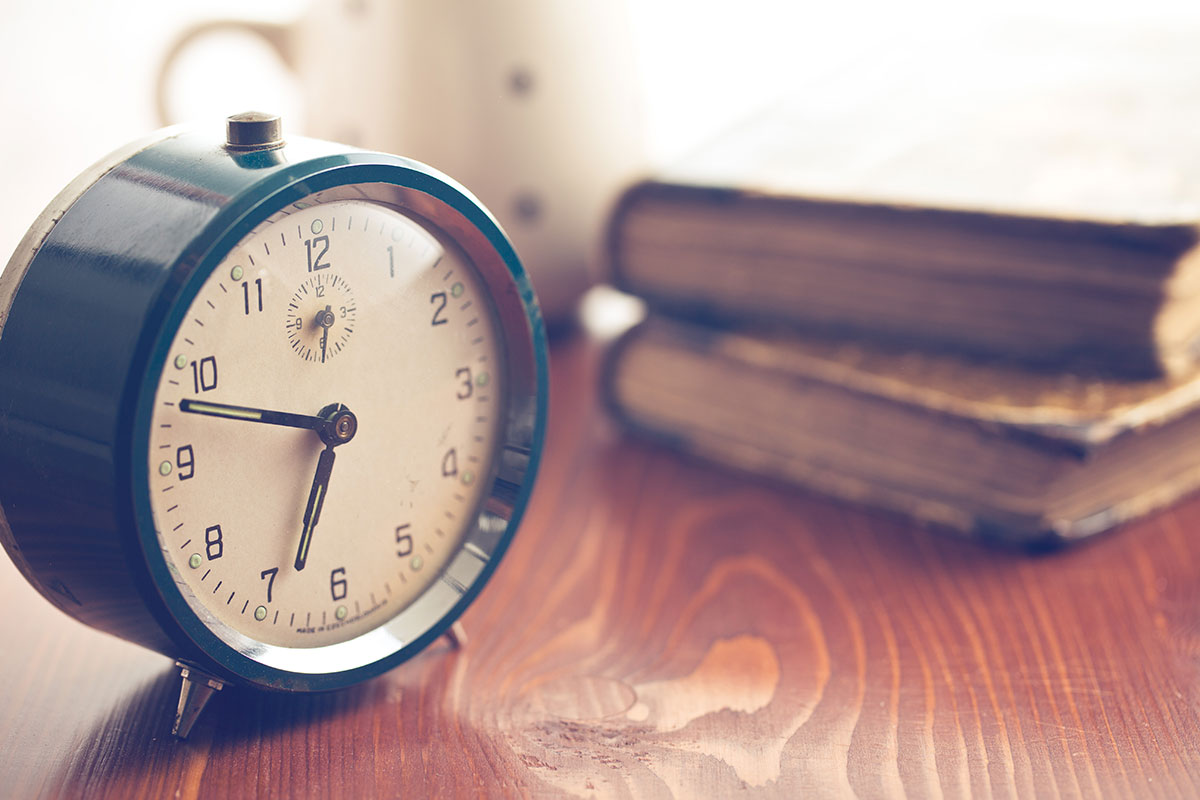 Alarm clock and books on a night stand