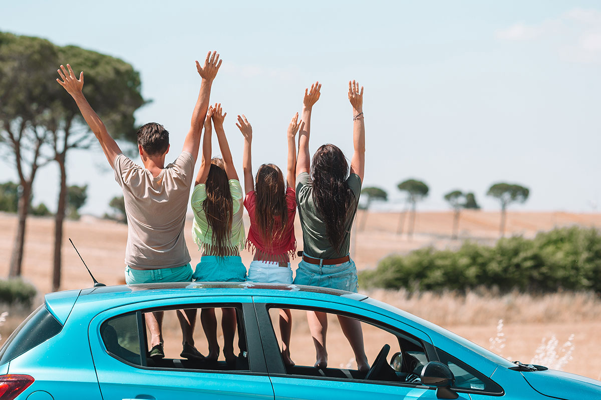 Family sitting on the roof of a car