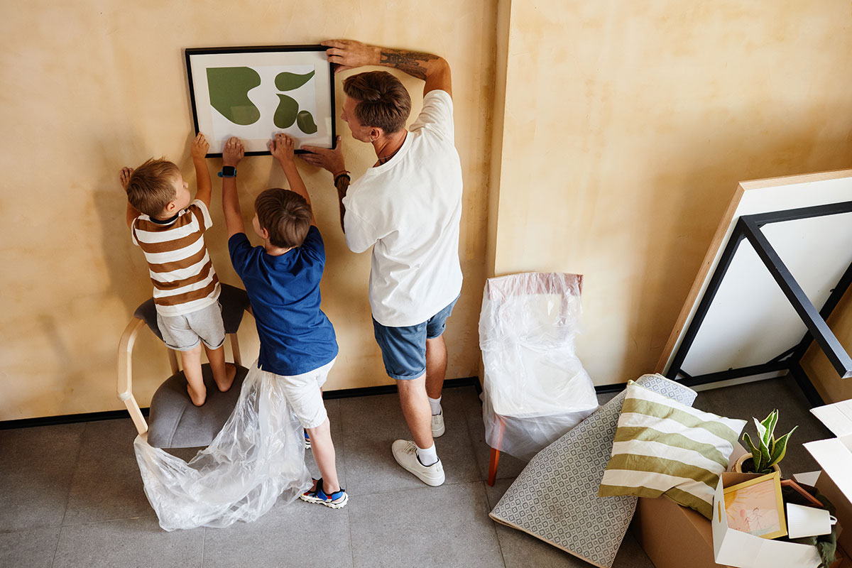 Father and sons hanging a picture