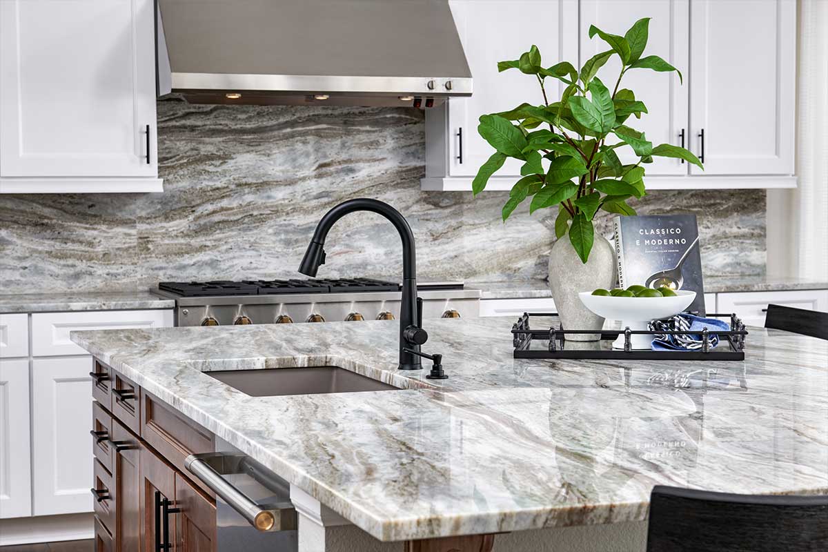 modern white kitchen with grey granite countertops and a matching backsplash