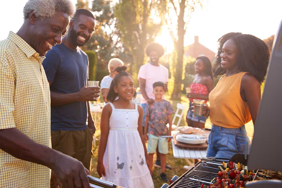 large family enjoying a bbq outside of one member's multigenerational households