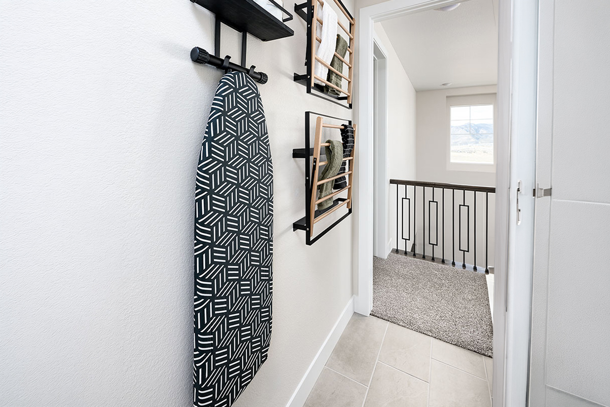 laundry room wall with hanging drying racks and other home storage solutions