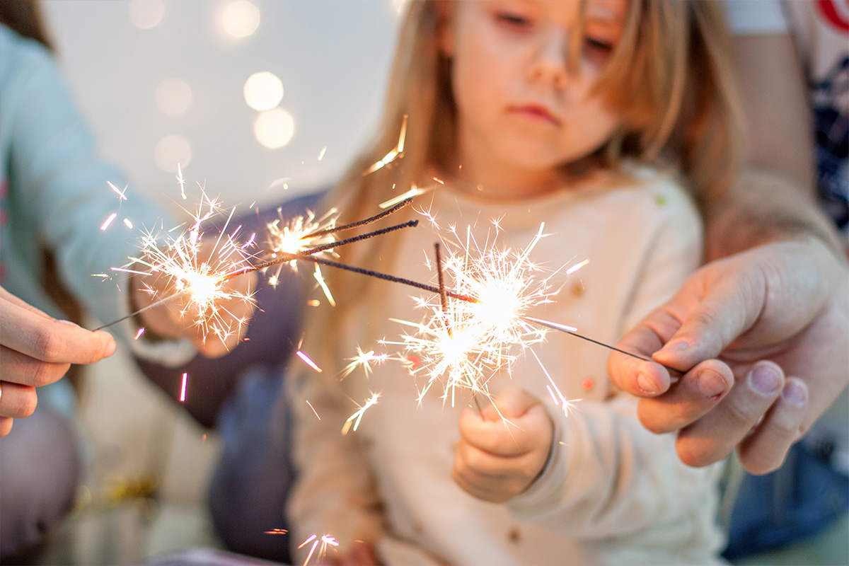 young girl and adults playing with sparkler