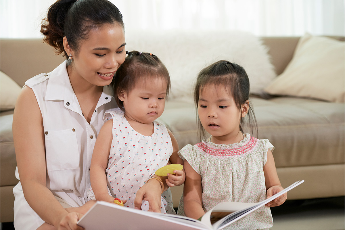 mother reading to two daughters
