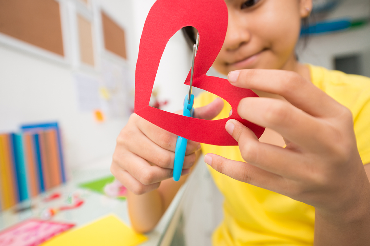A child cutting a paper heart