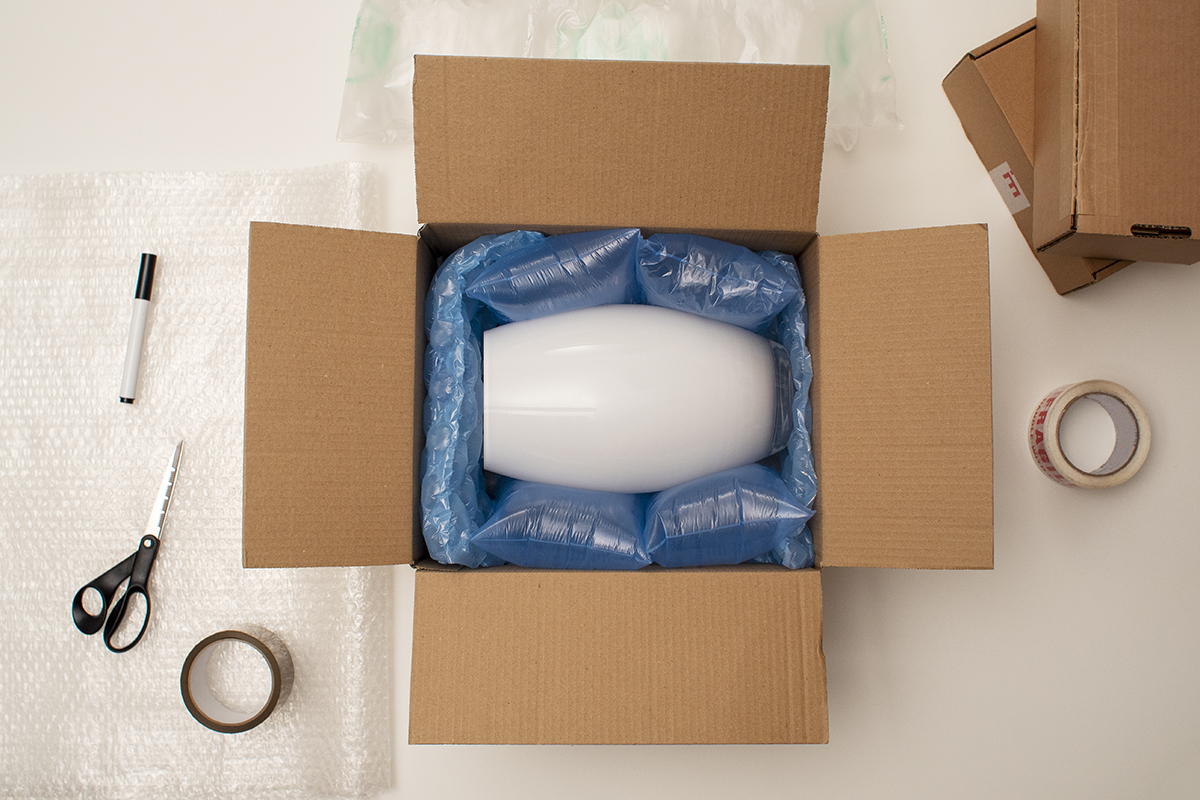 Cardboard box, tape, bubble wrap, scissors and marker pen.